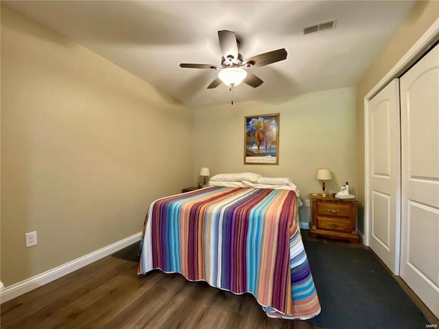 bedroom with dark hardwood / wood-style floors, ceiling fan, and a closet