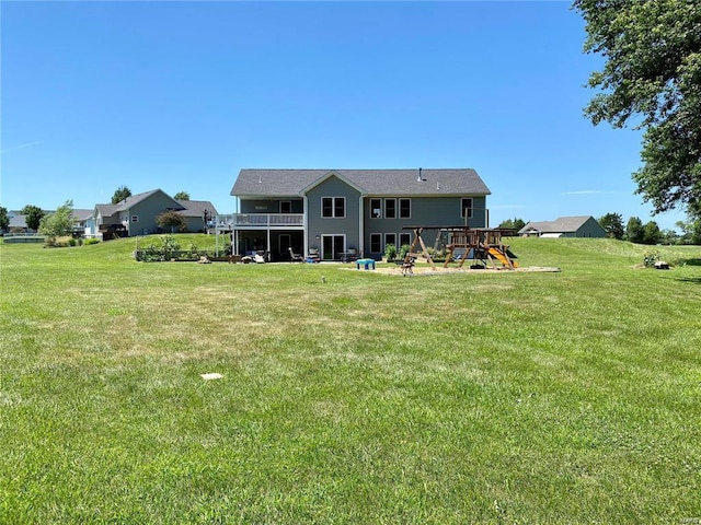 back of house featuring a yard and a playground