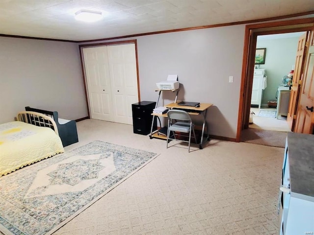 bedroom with crown molding, washer / dryer, light carpet, and a closet