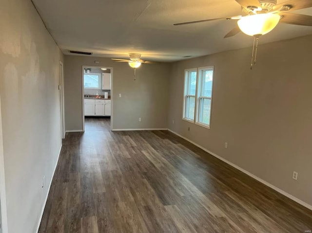 unfurnished room with dark wood-type flooring and ceiling fan