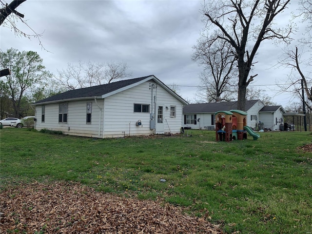 back of property with a playground and a yard