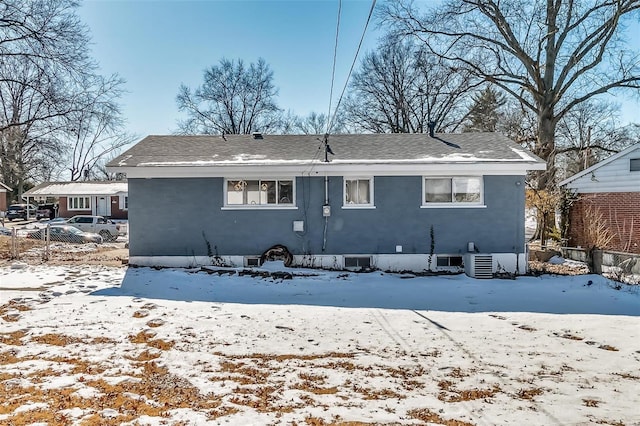 snow covered back of property with central AC