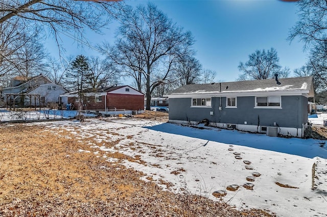 snow covered rear of property with central AC