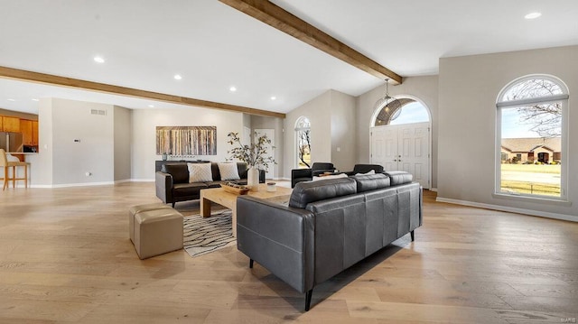 living room with vaulted ceiling with beams and light hardwood / wood-style floors