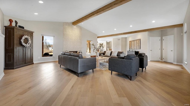 living room featuring lofted ceiling with beams and light hardwood / wood-style floors