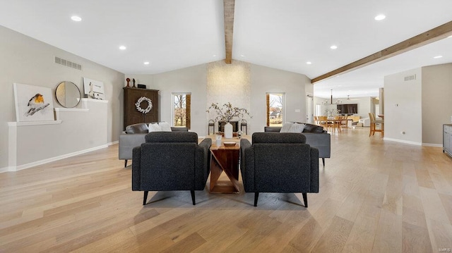 living room featuring vaulted ceiling with beams and light wood-type flooring