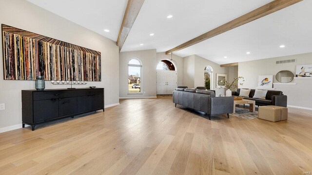 living room featuring lofted ceiling with beams and light wood-type flooring