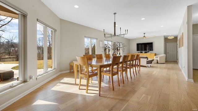 dining area with light hardwood / wood-style flooring and a chandelier