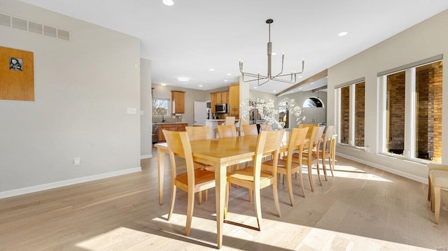 dining room featuring a chandelier and light wood-type flooring