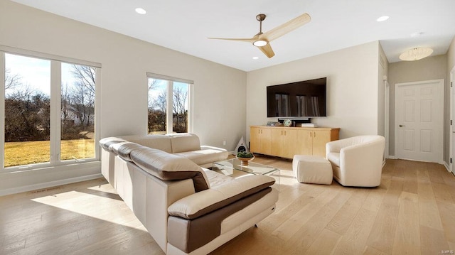 living room featuring a wealth of natural light, ceiling fan, and light wood-type flooring