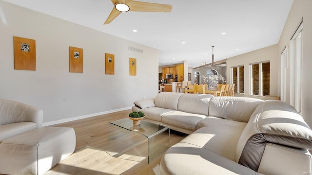 living room featuring light hardwood / wood-style flooring and ceiling fan