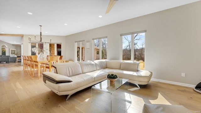 living room with light hardwood / wood-style flooring and a notable chandelier