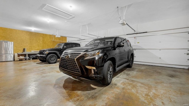 garage with a garage door opener and stainless steel refrigerator