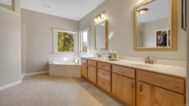 bathroom with tile patterned flooring, vanity, and a tub to relax in