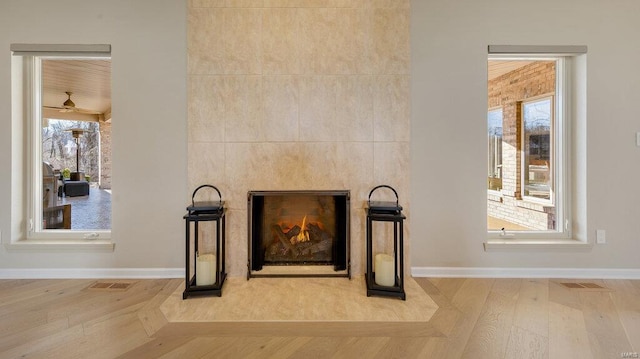 details featuring a tile fireplace and hardwood / wood-style floors