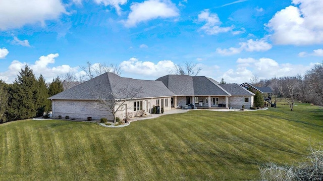 rear view of property with a patio and a lawn