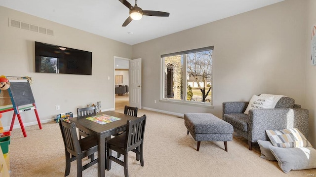 dining area featuring light colored carpet and ceiling fan