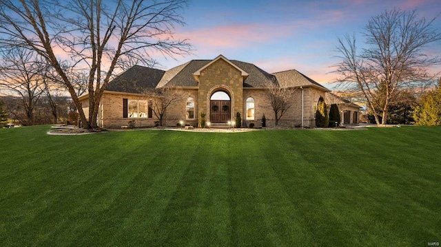 french provincial home featuring a lawn