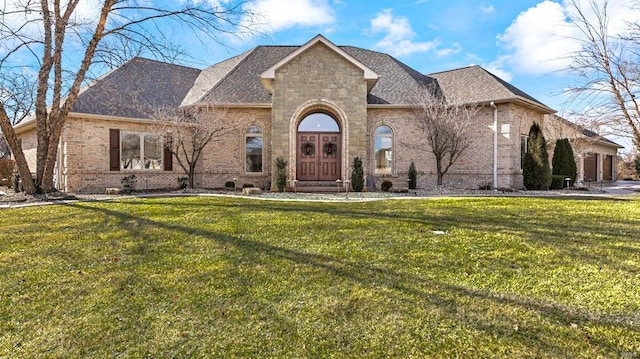 french country inspired facade featuring a front lawn