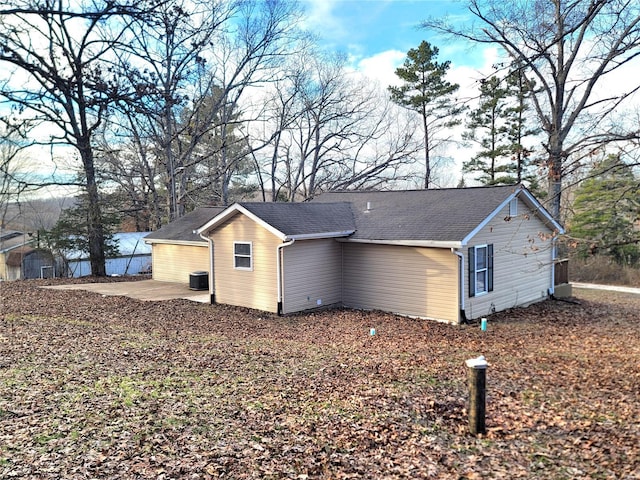 view of side of property with a patio area and central air condition unit