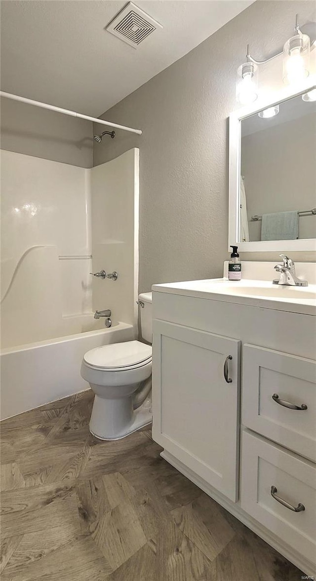 full bathroom featuring bathing tub / shower combination, vanity, and toilet