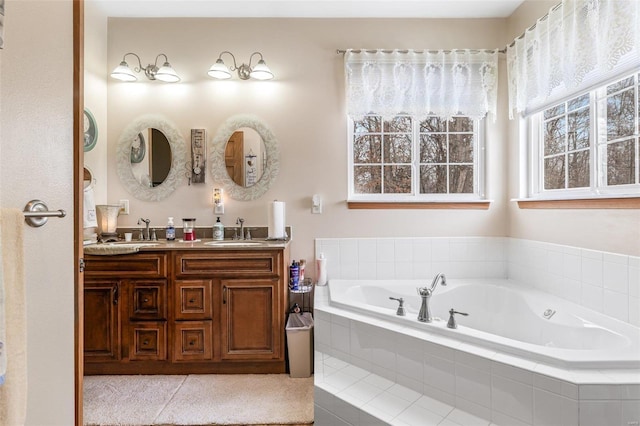 bathroom featuring a relaxing tiled tub and vanity