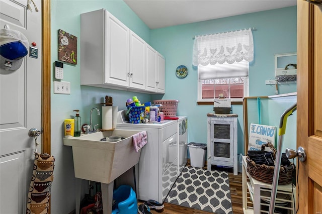 laundry room featuring dark hardwood / wood-style floors, washing machine and dryer, and cabinets