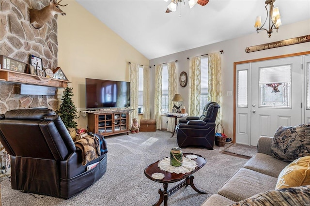 living room featuring high vaulted ceiling, ceiling fan with notable chandelier, and light colored carpet