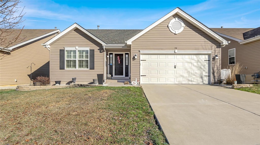 ranch-style home featuring a garage and a front lawn