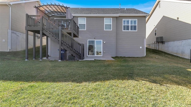 back of house with central AC, a deck, and a lawn