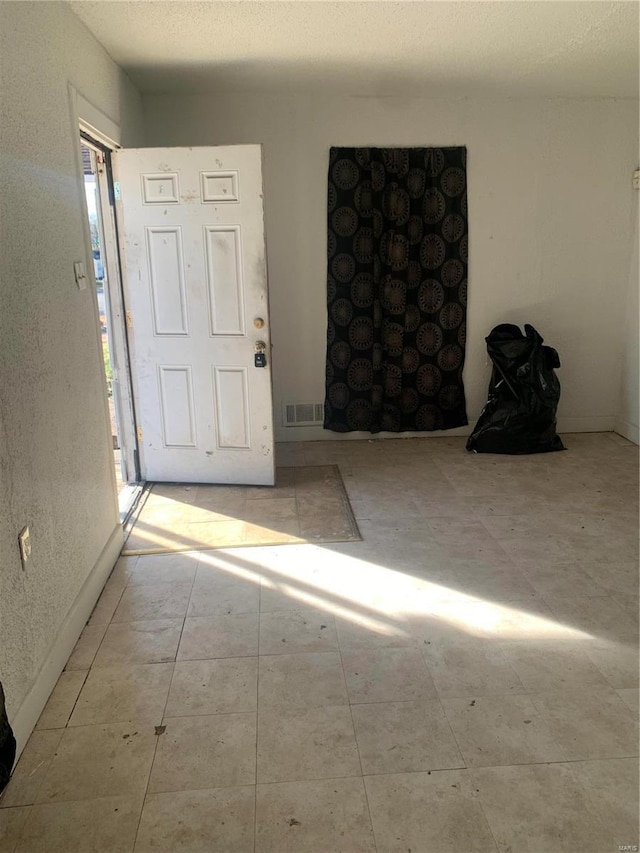 unfurnished room featuring a textured ceiling