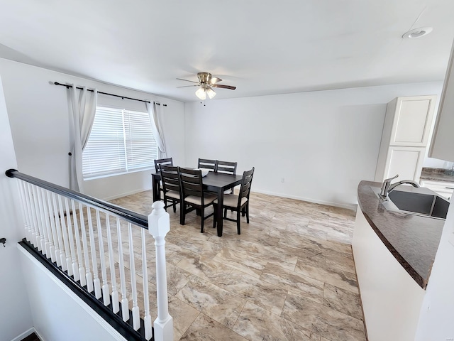 dining room featuring ceiling fan and sink