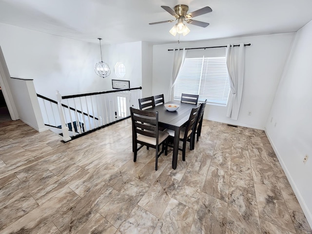 dining room with ceiling fan with notable chandelier