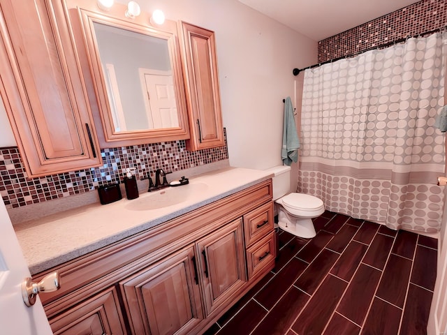 bathroom with vanity, backsplash, and toilet