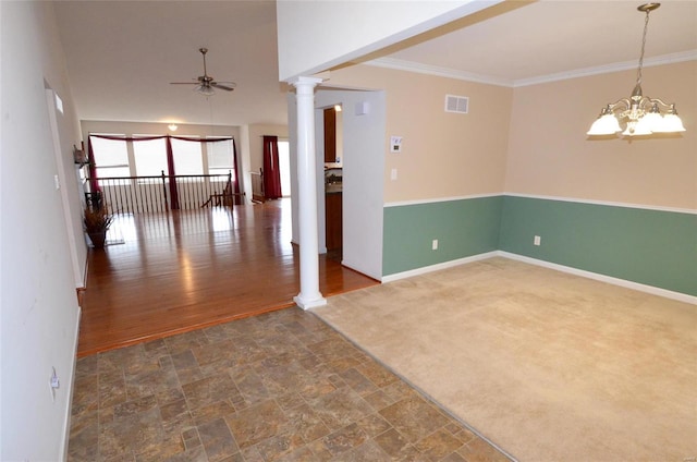 spare room with ornate columns, crown molding, ceiling fan with notable chandelier, and dark carpet