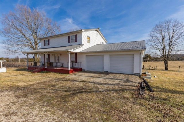 view of front of house with a garage, a front yard, and covered porch