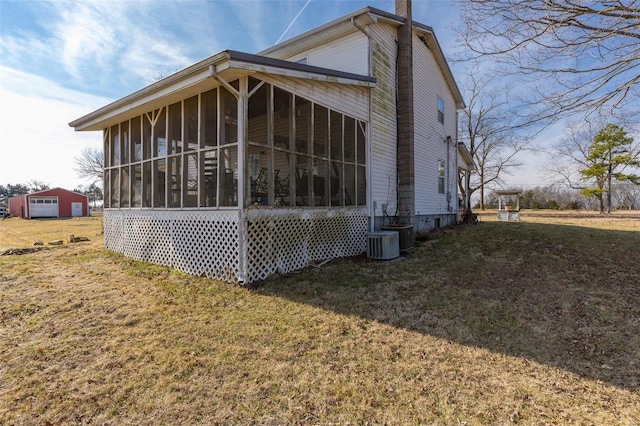 view of side of property with a yard, a sunroom, and central air condition unit