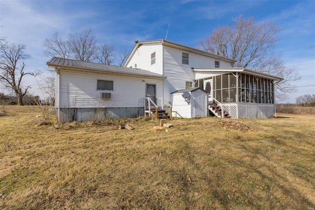 back of property with a sunroom and a lawn