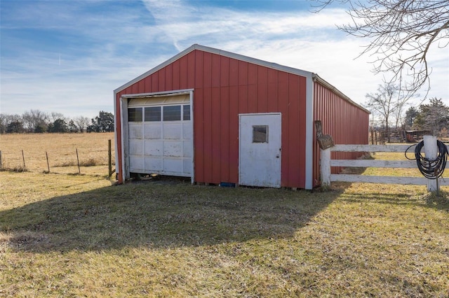 view of outbuilding featuring a garage, a rural view, and a lawn