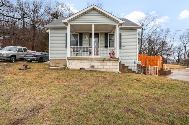 bungalow featuring covered porch and a front lawn