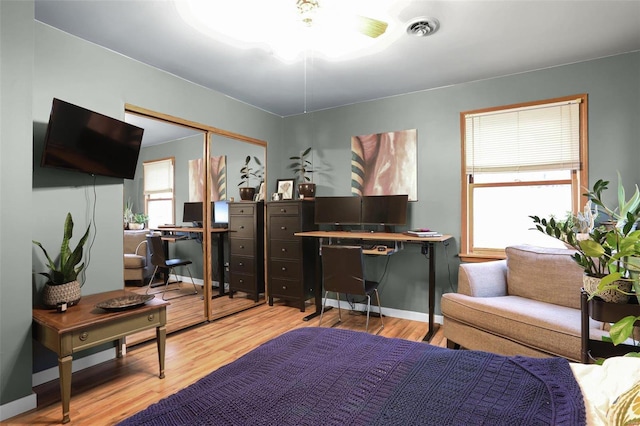 bedroom with a closet and light hardwood / wood-style flooring