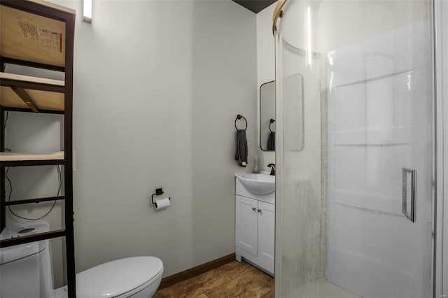 bathroom featuring vanity, a shower with shower door, and toilet