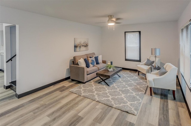 living room with ceiling fan, plenty of natural light, and light hardwood / wood-style flooring