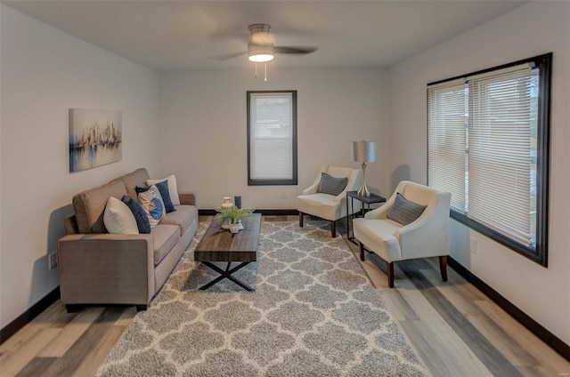 living room featuring wood-type flooring, a healthy amount of sunlight, and ceiling fan