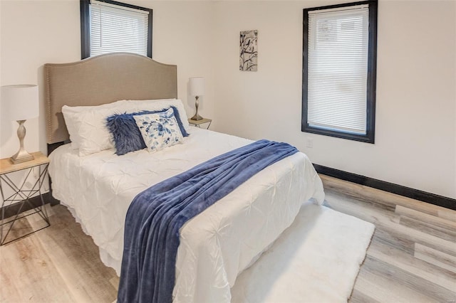 bedroom featuring multiple windows and light wood-type flooring