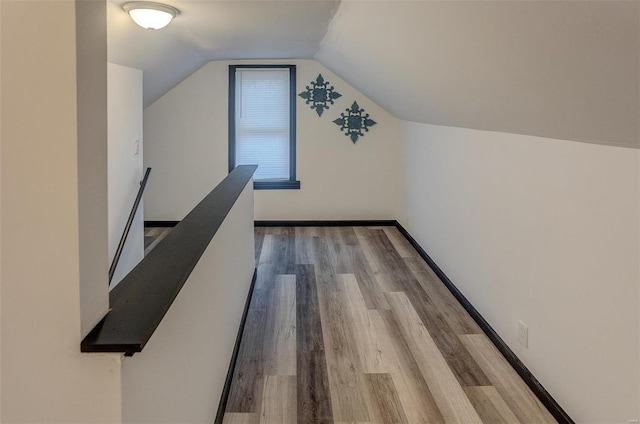 additional living space with hardwood / wood-style flooring and vaulted ceiling