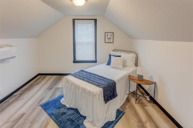 bedroom featuring vaulted ceiling and light hardwood / wood-style flooring