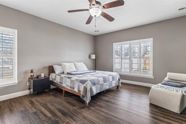 bedroom with visible vents, baseboards, dark wood finished floors, and a ceiling fan