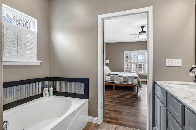 full bathroom featuring baseboards, a ceiling fan, connected bathroom, vanity, and a bath