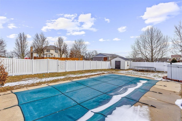 view of swimming pool featuring a storage unit, an outdoor structure, a fenced backyard, and a fenced in pool
